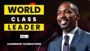 Engaged leader speaking into a microphone beside bold yellow and white text reading “World Class Leader Vol. 1 Leadership Foundations” against a dark backdrop