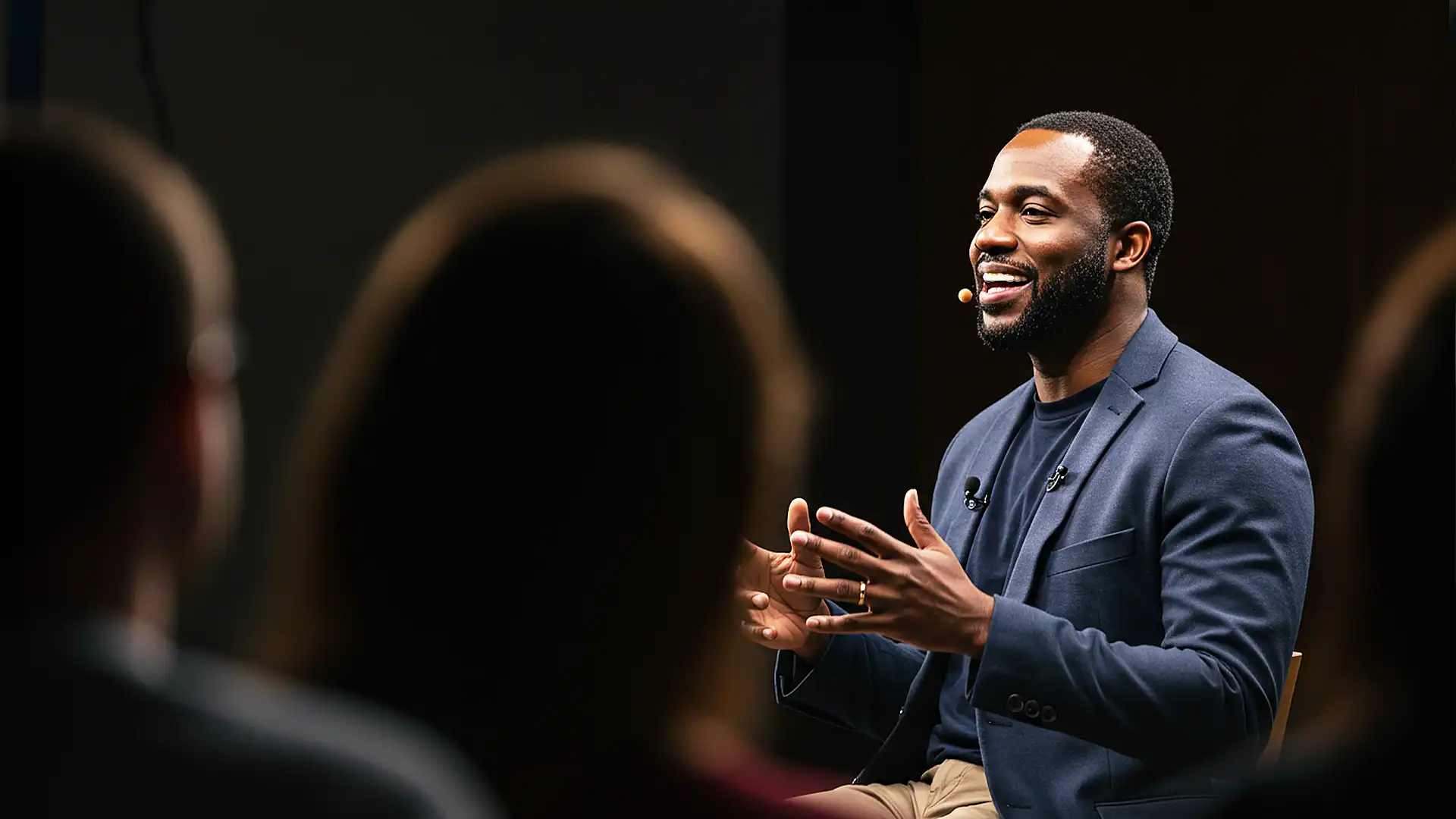 A professional coach speaking passionately to an audience during an nRecovery personal development workshop or seminar.