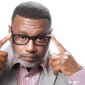 J. D. Lawrence, known as 'The King of Dramedy,' wearing glasses and pointing to his temples, symbolizing thought and mental focus.